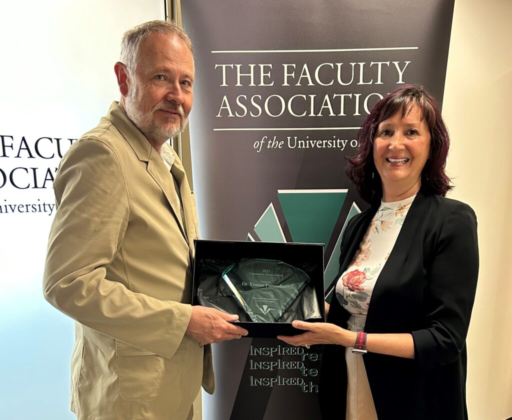 Faculty Association President David Stewart (L) presents the Community Service Award to Professor Yvonne Poitras Pratt (R).